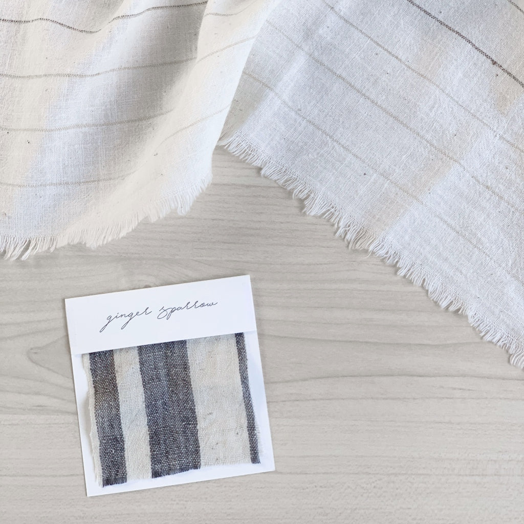 Handwoven Textile by Ginger Sparrow, a modern home decor brand. Featuring a charcoal black stripe pattern woven on a soft ivory ground. Light and airy its perfect for #throwpillows #drapes #livingroomdecor #bedroomideas