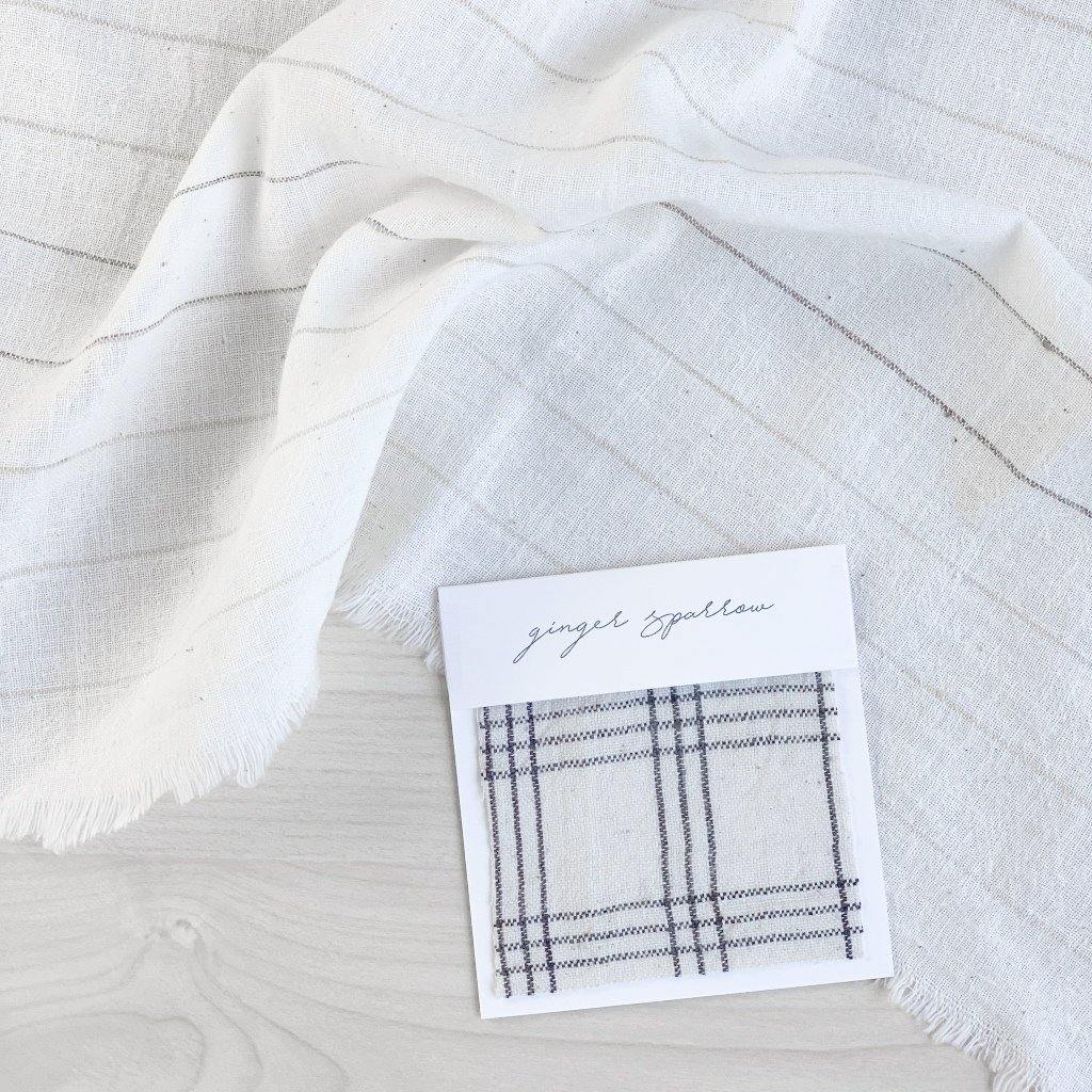 Handwoven Textile by Ginger Sparrow, a modern home decor brand. Featuring a charcoal black plaid pattern woven on a soft ivory ground. Light and airy its perfect for #throwpillows #drapes #livingroomdecor #bedroomideas