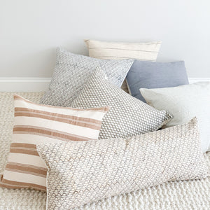 A soft ivory and brown striped handwoven cotton pillow . Handcrafted by Ginger Sparrow, a modern home decor brand.