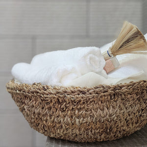 Detail view of a banana Fiber basket with a wide Mouth and low profile. Use as a shelf accent or store linen, towels, or flowers etc. 