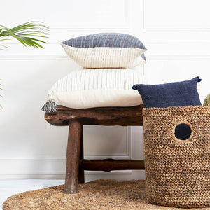 A soft ivory pillow in 22x22 inch size featuring fawn and indigo striped weave and lush corner tassels.