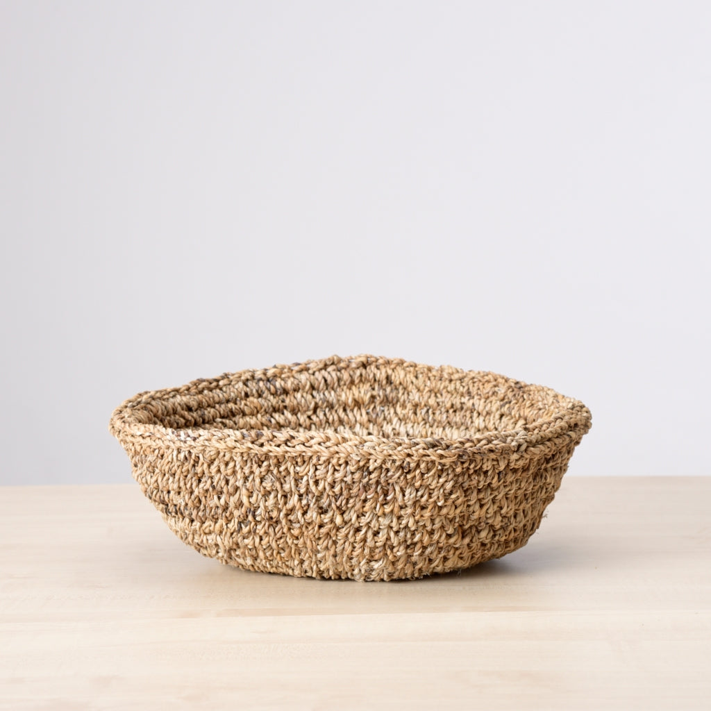 Detail view of a banana Fiber basket with a wide Mouth and low profile. Use as a shelf accent or store linen, towels, or flowers etc. 