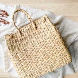 Watergrass Hamper Baskets in a light buttery golden hue. Handcrafted in 3 nesting sizes, great as a picnic hamper baskets. Crafted by Ginger Sparrow, a modern home decor brand. 