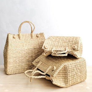 Watergrass Hamper Baskets in a light buttery golden hue. Handcrafted in 3 nesting sizes, great as a picnic hamper baskets. Crafted by Ginger Sparrow, a modern home decor brand. 