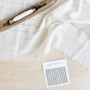 Handwoven Textile by Ginger Sparrow, a modern home decor brand. Featuring a charcoal black stripe pattern woven on a soft ivory ground. Light and airy its perfect for #throwpillows #drapes #livingroomdecor #bedroomideas