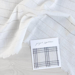 Handwoven Textile by Ginger Sparrow, a modern home decor brand. Featuring a charcoal black plaid pattern woven on a soft ivory ground. Light and airy its perfect for #throwpillows #drapes #livingroomdecor #bedroomideas