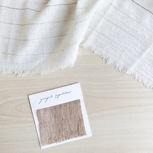 Handwoven Textile by Ginger Sparrow, a modern home decor brand. Featuring a brown thick stripe woven on a soft ivory ground. Light and airy its perfect for #throwpillows #drapes #livingroomdecor #bedroomideas