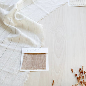 Handwoven Textile by Ginger Sparrow, a modern home decor brand. Featuring a brown thick stripe woven on a soft ivory ground. Light and airy its perfect for #throwpillows #drapes #livingroomdecor #bedroomideas