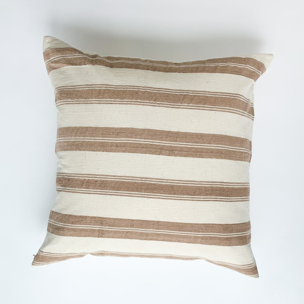 A soft ivory and brown striped handwoven cotton pillow . Handcrafted by Ginger Sparrow, a modern home decor brand.