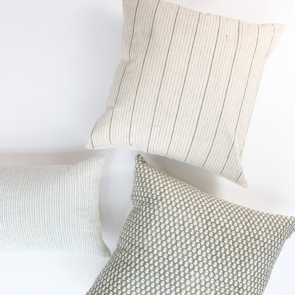 A soft ivory pillow featuring a charcoal striped pattern. Handcrafted by Ginger Sparrow, a modern home decor brand.